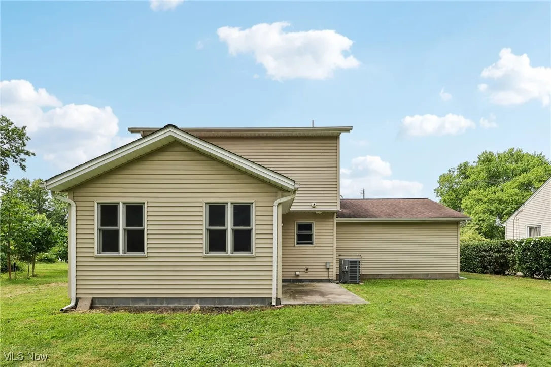 Rear view of property featuring a lawn and a patio