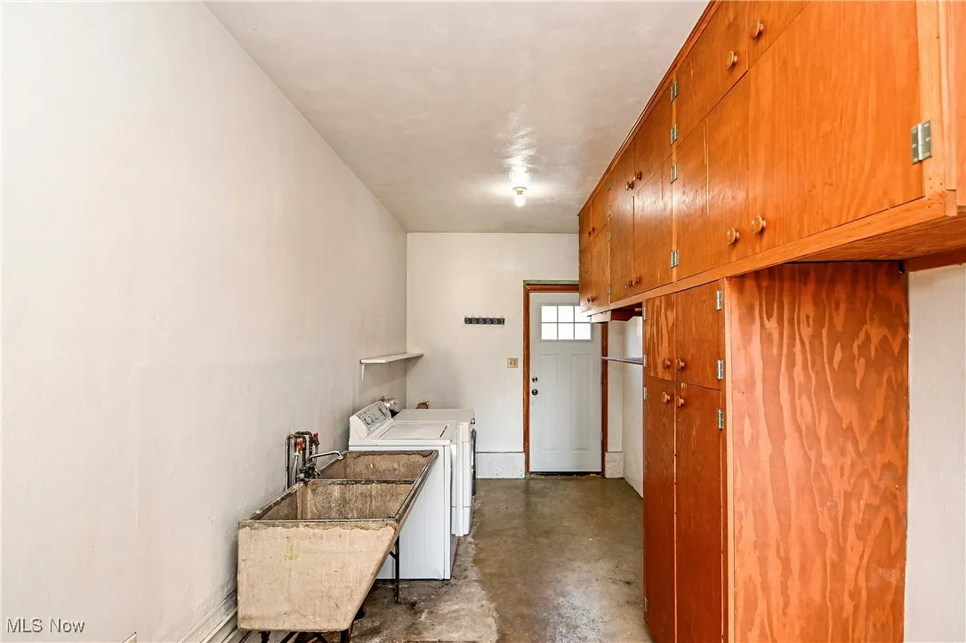 Laundry area with separate washer and dryer and a sink