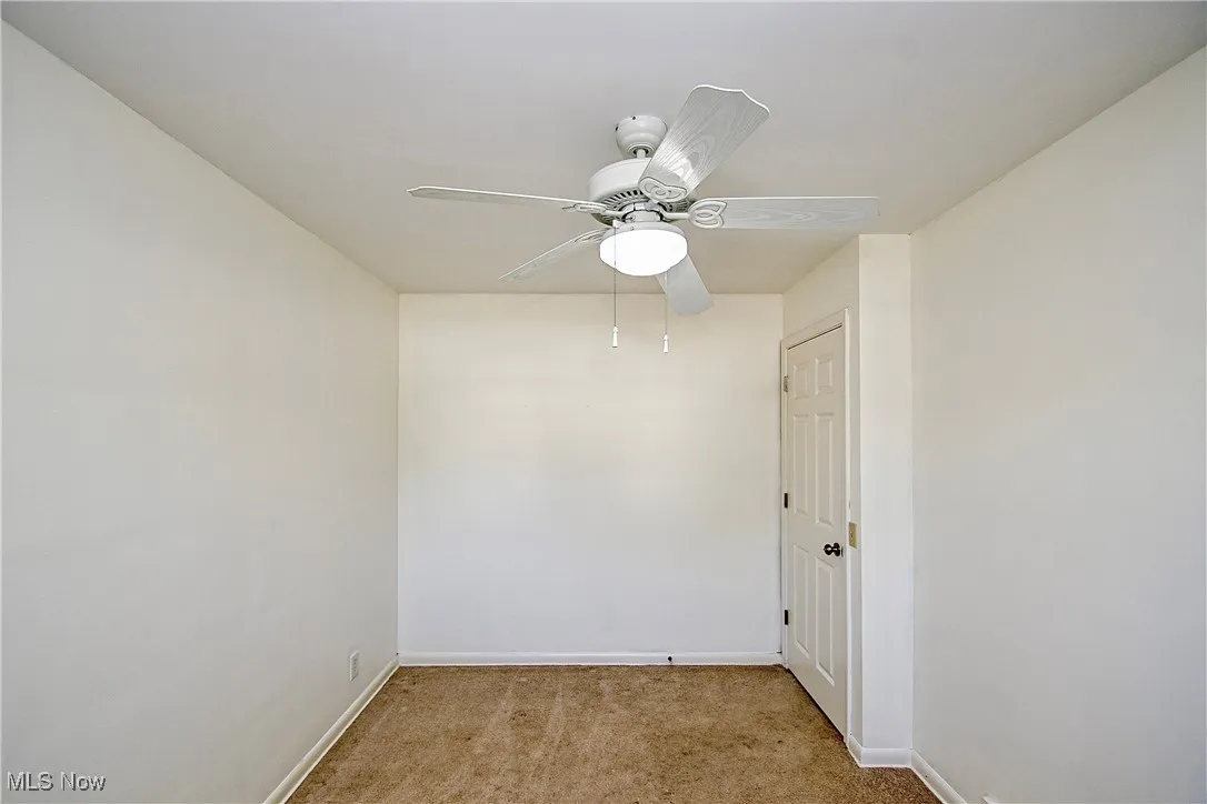 Spare room featuring light carpet and ceiling fan