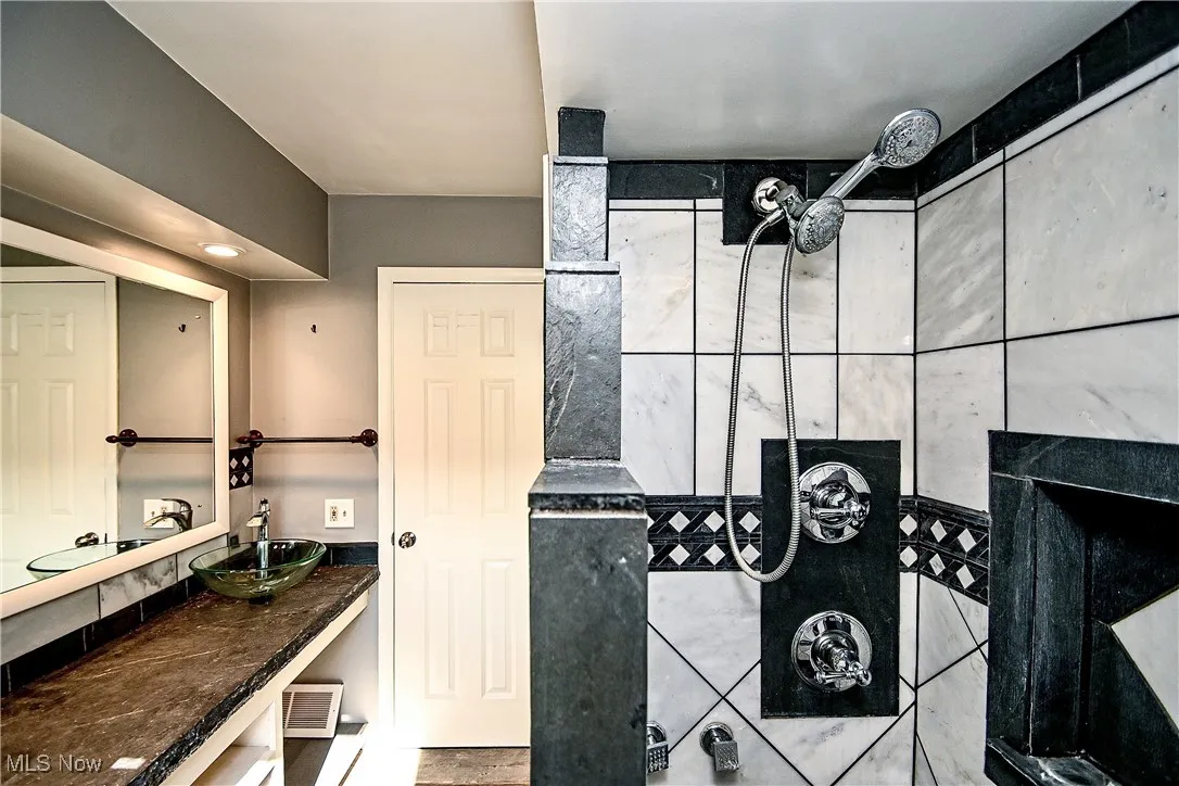 Full bath with a tile shower and vanity