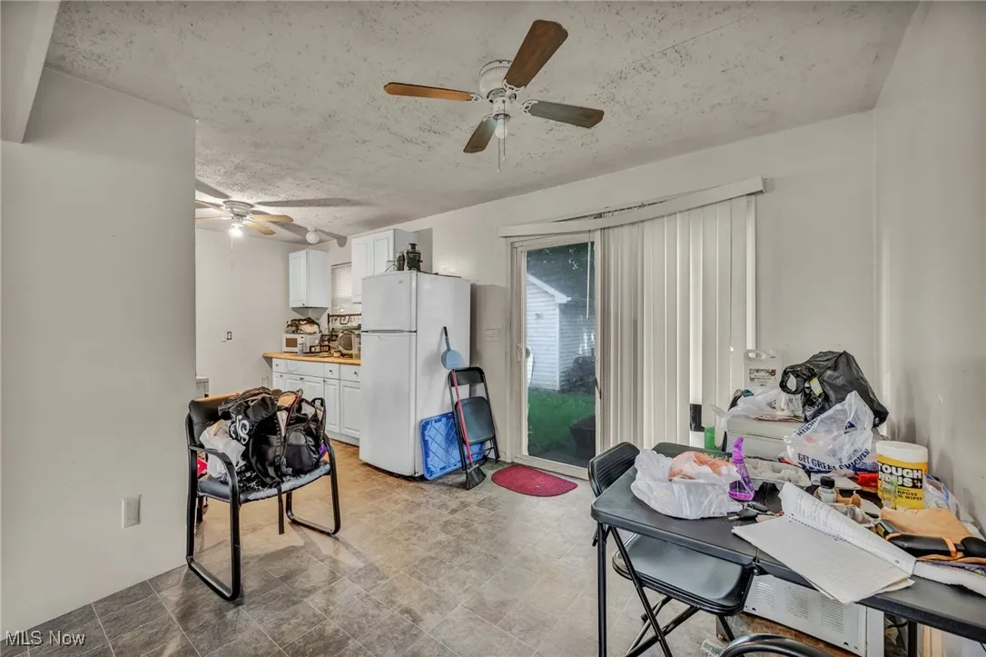 Dining area featuring a ceiling fan and a textured ceiling