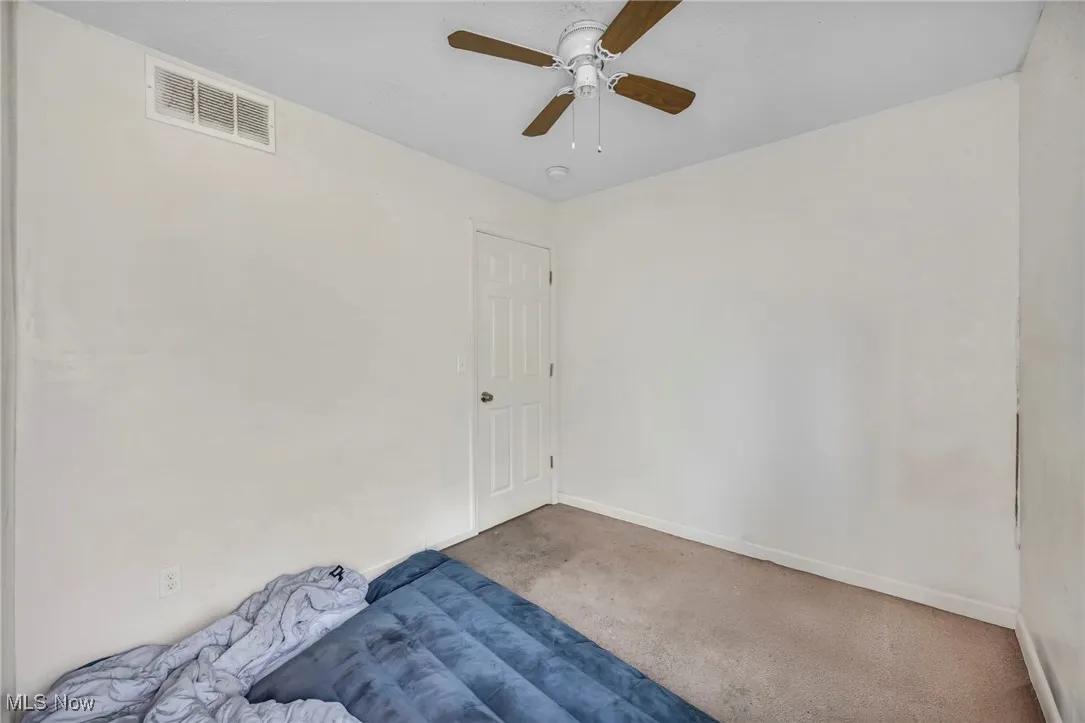 Spare room featuring carpet floors and ceiling fan