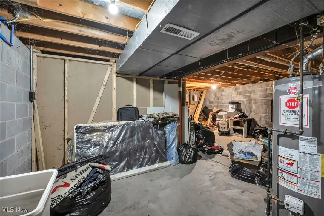 Unfinished basement featuring water heater and a sink