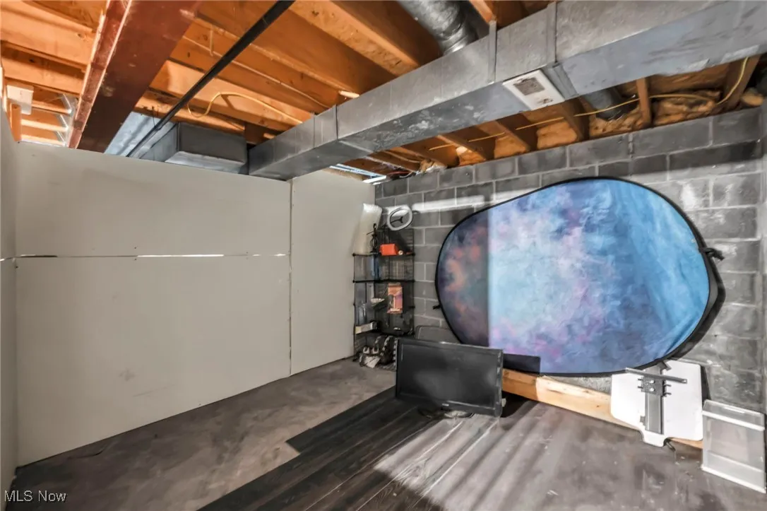 Unfinished basement featuring concrete block wall