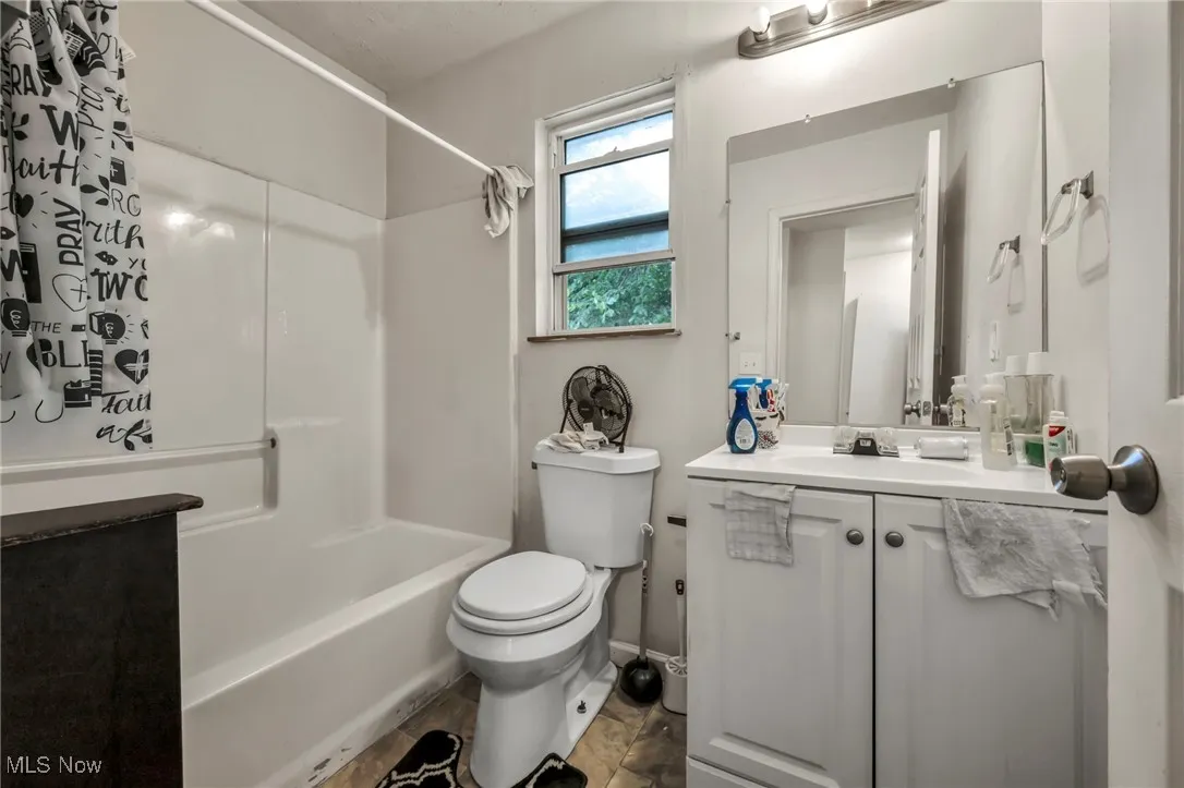 Full bath featuring vanity and shower / bath combination with curtain