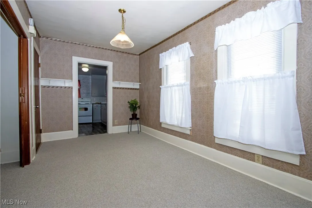 Empty room with carpet flooring and wallpapered walls
