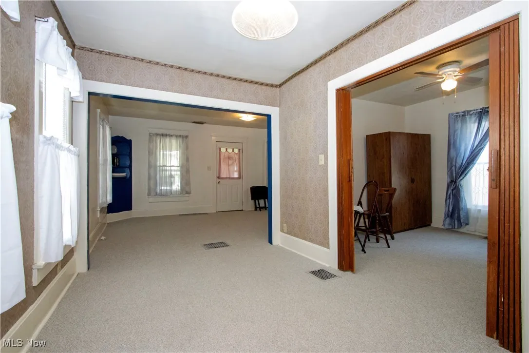 Corridor with wallpapered walls and carpet floors