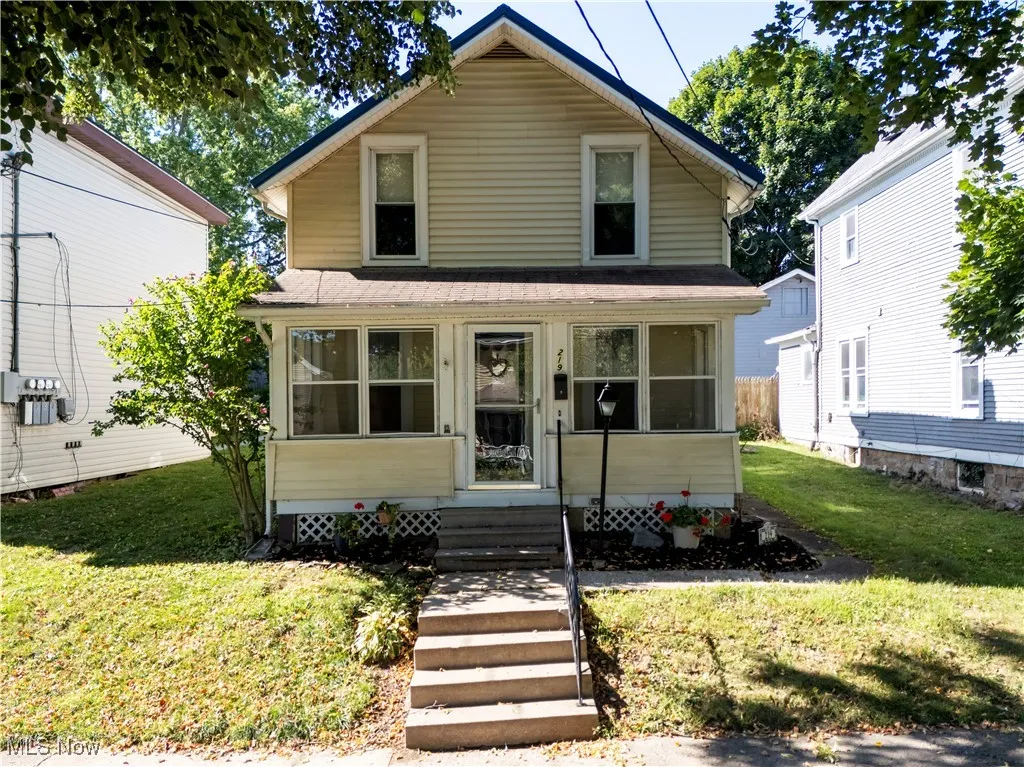 American foursquare style home with a sunroom, a front yard, and a shingled roof