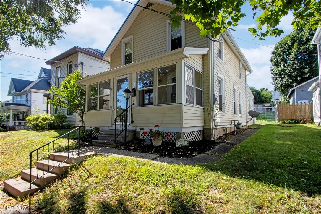 View of front of house with entry steps and a sunroom