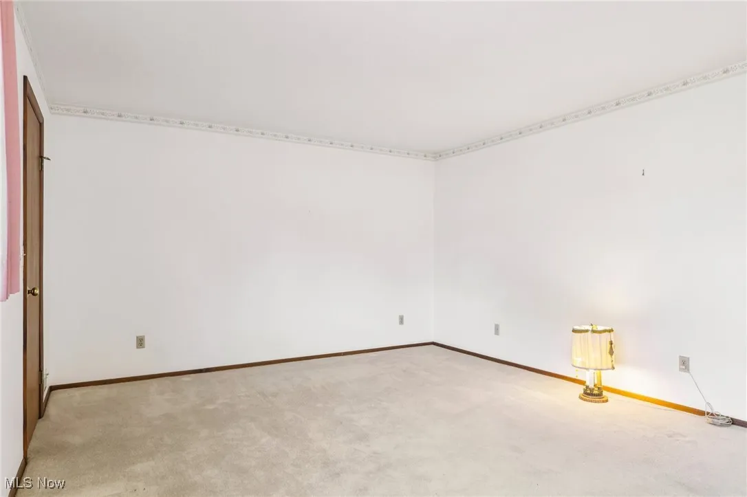 Carpeted empty room with baseboards
