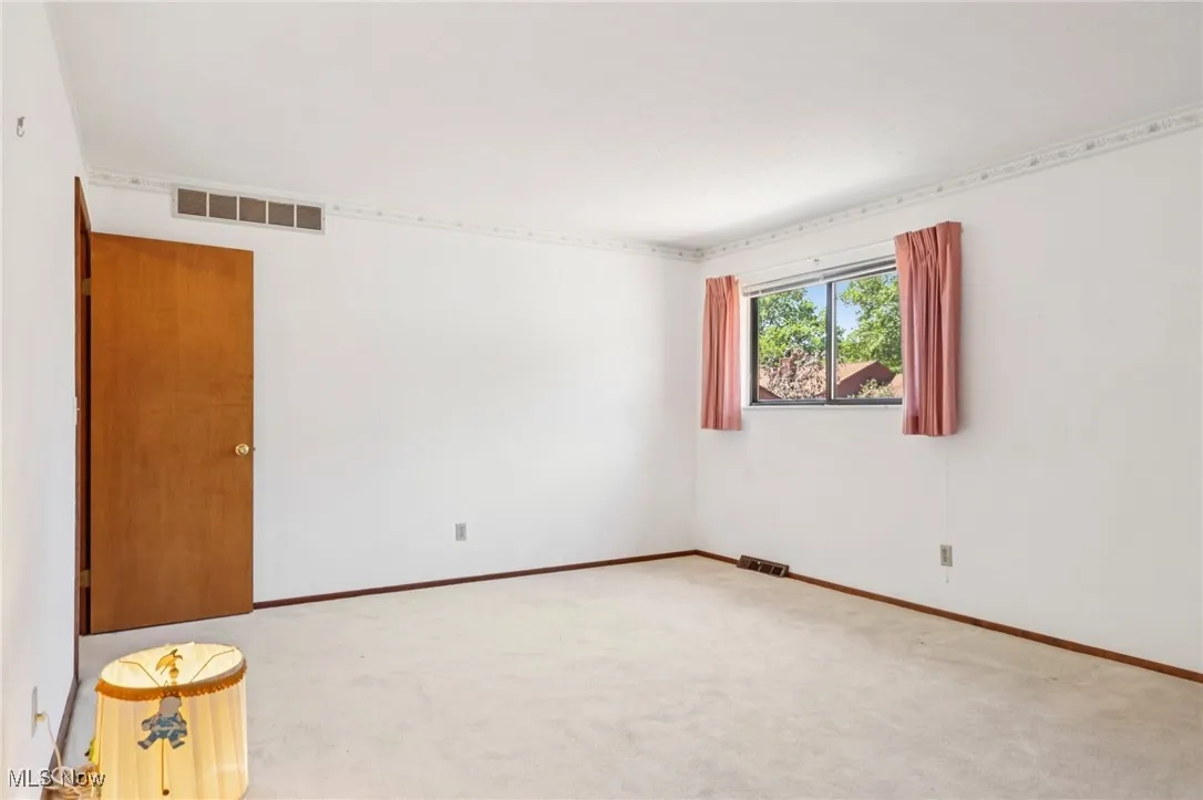 Carpeted spare room featuring baseboards