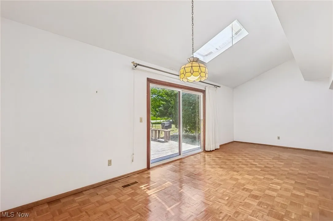 Spare room featuring vaulted ceiling and a skylight