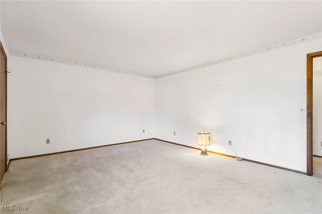 Carpeted empty room featuring baseboards