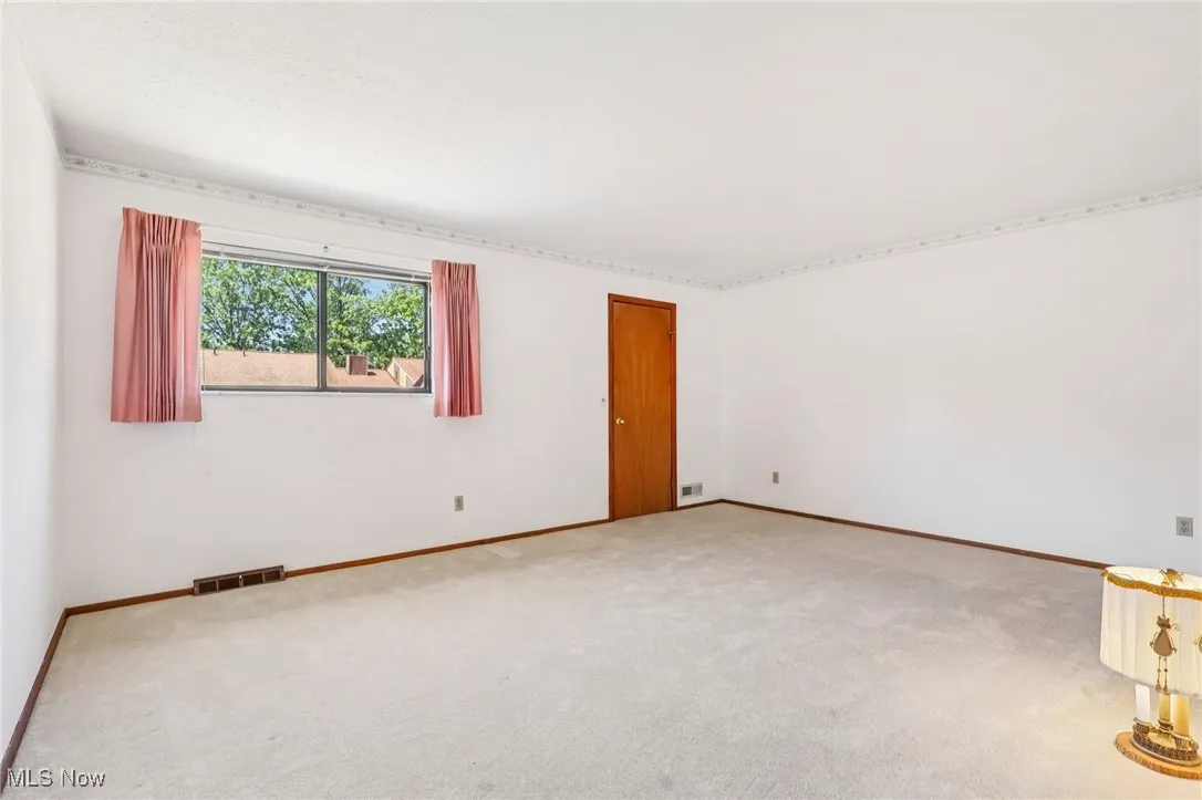 Carpeted empty room featuring baseboards