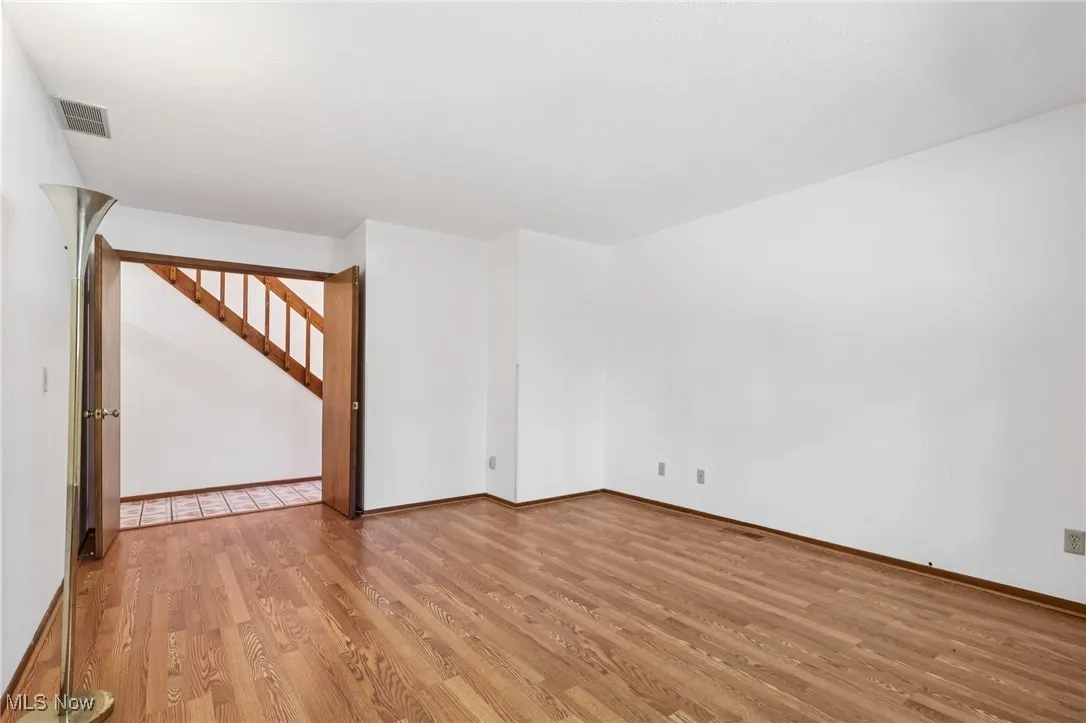 Empty room with light wood-type flooring and stairway