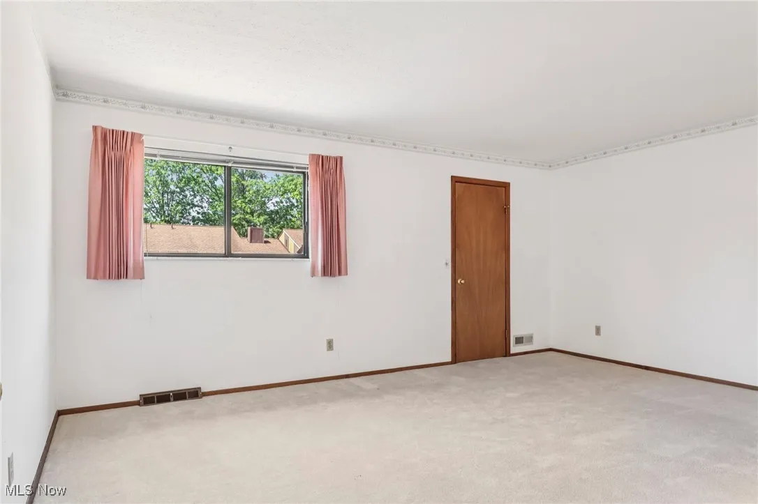 Carpeted empty room with baseboards