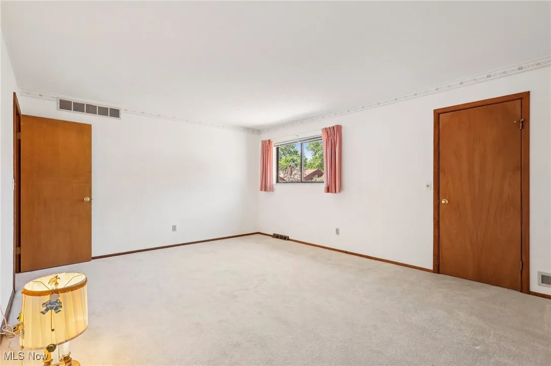 Empty room featuring carpet flooring and baseboards