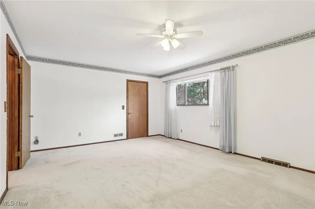 Spare room featuring carpet flooring and a ceiling fan