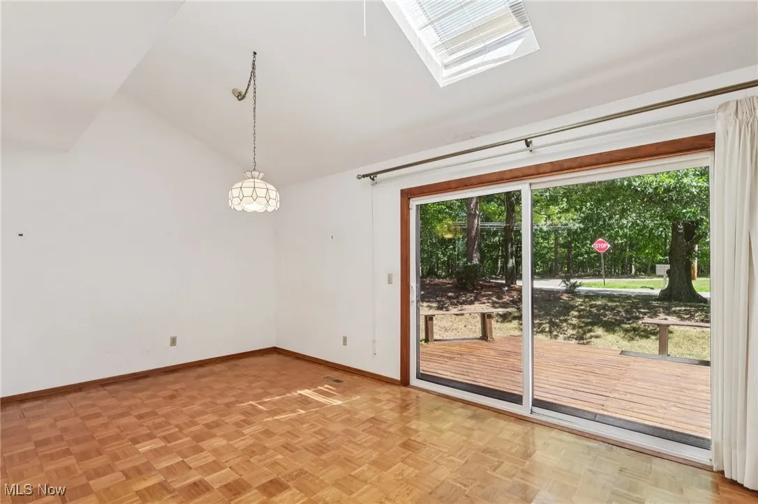 Doorway featuring lofted ceiling and baseboards