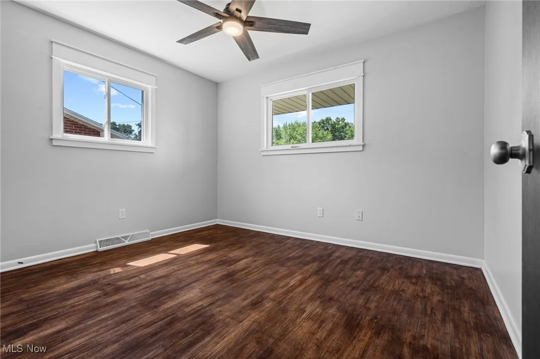 Bedroom #3 featuring plenty of natural light, dark wood-style floors, and a ceiling fan/light