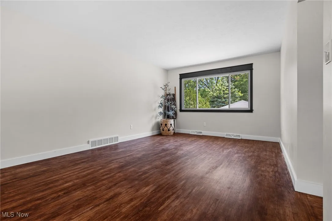 Living room with dark wood-style floors and new picture window