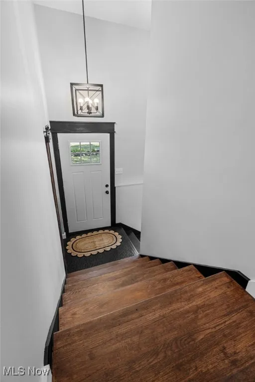 Stairs with a chandelier and barn door to closet