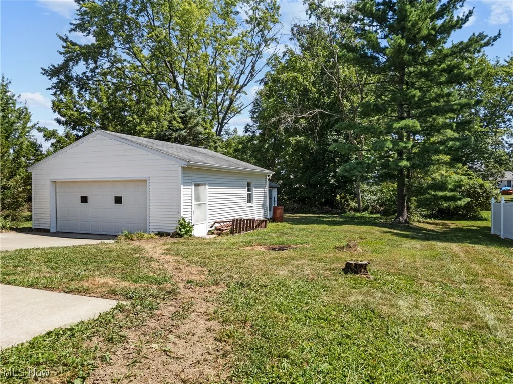 View of grassy yard with an oversized garage and a shed
