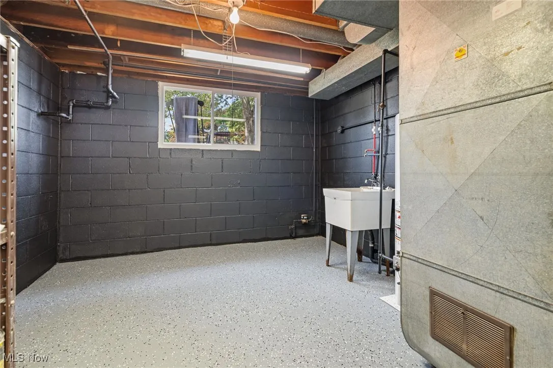 Basement featuring laundry, utility sink & storage