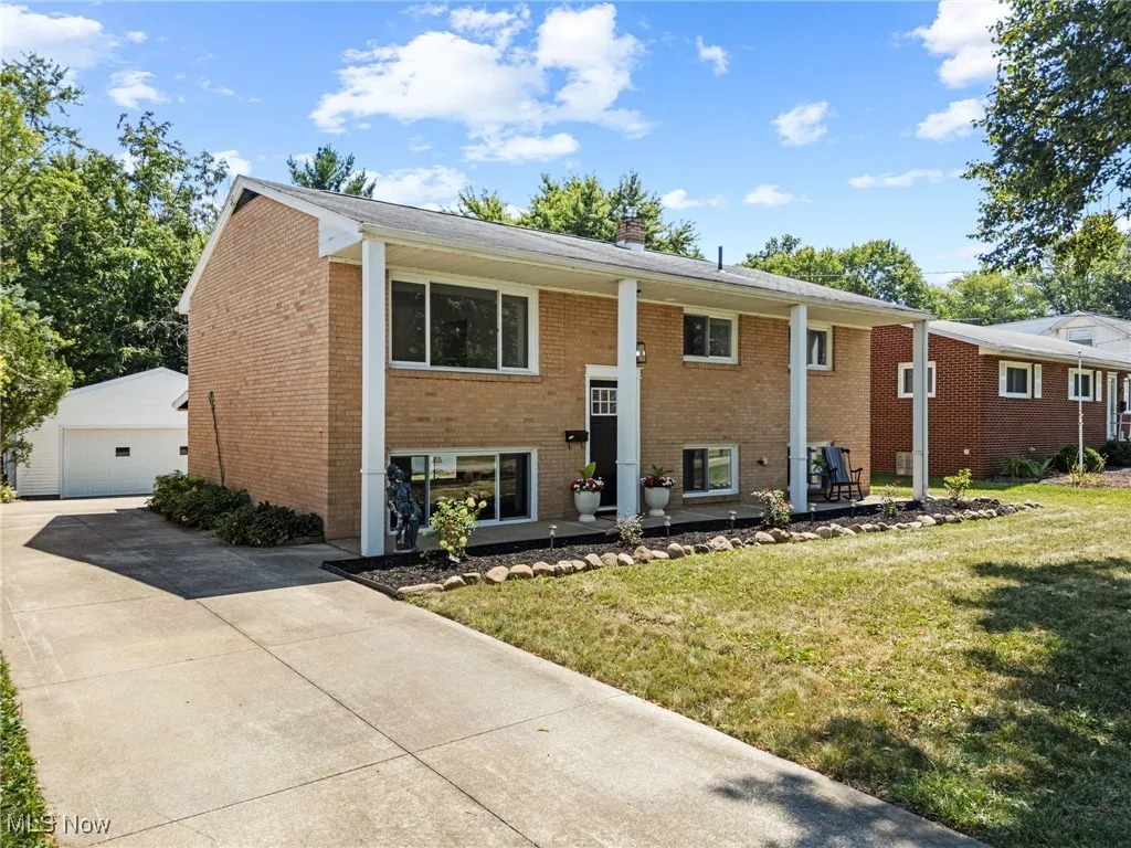 Split foyer home with brick exterior, concrete driveway an oversized garage