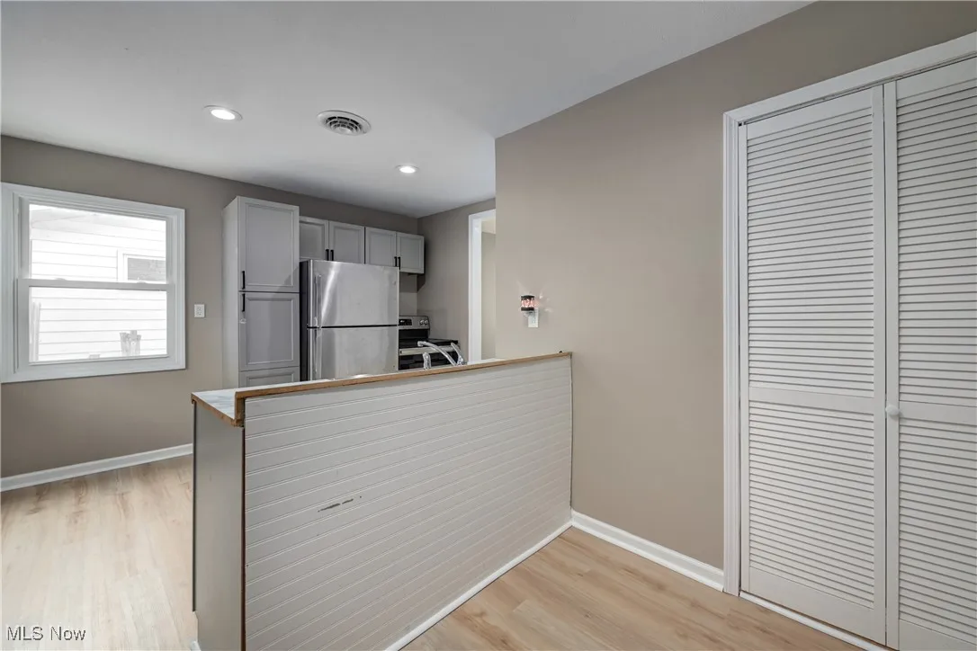 Kitchen with stainless steel appliances, gray cabinetry, light wood finished floors, recessed lighting, and a peninsula
