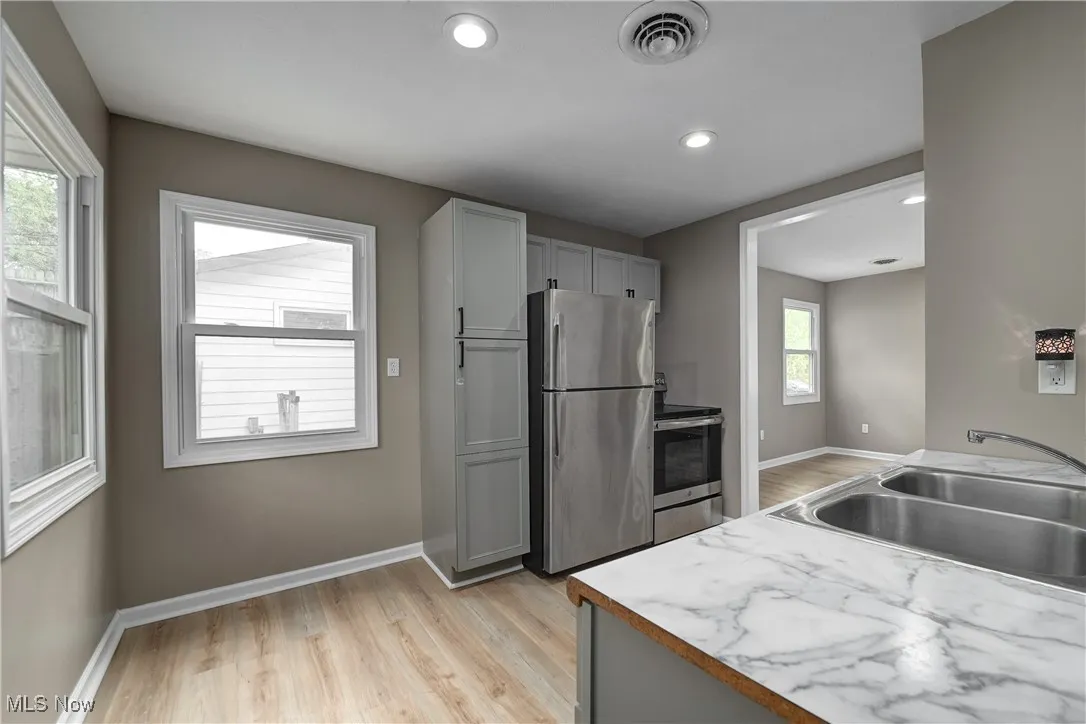 Kitchen featuring stainless steel appliances, gray cabinets, light wood-style floors, light countertops, and recessed lighting