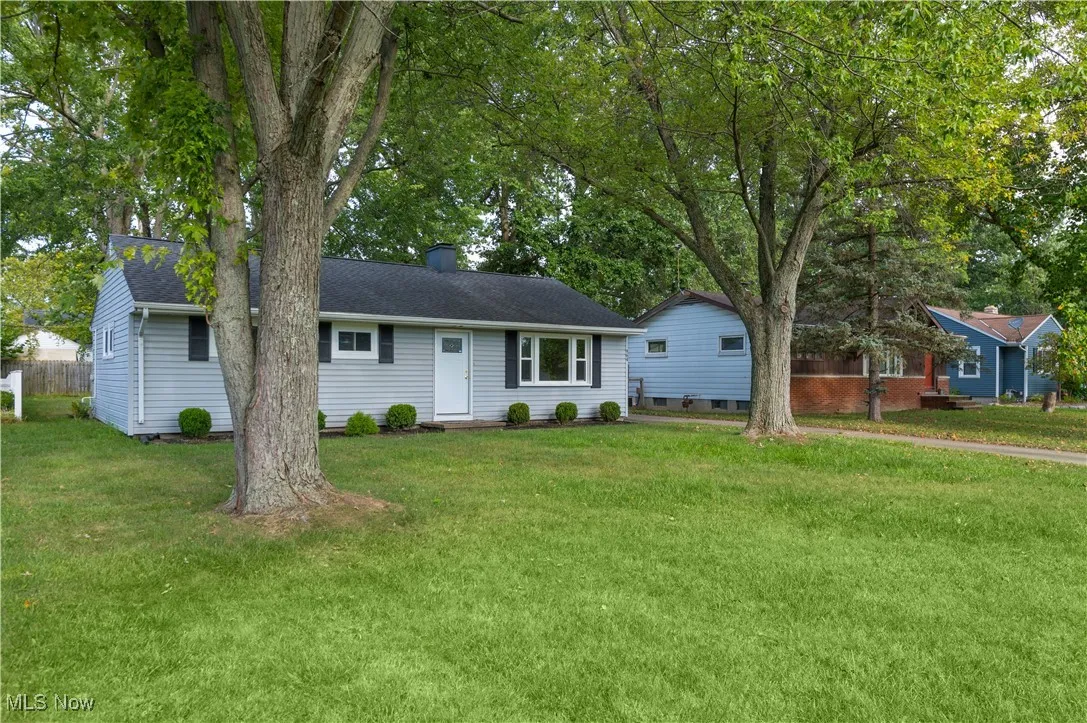 Ranch-style home with a front lawn, a chimney, and roof with shingles