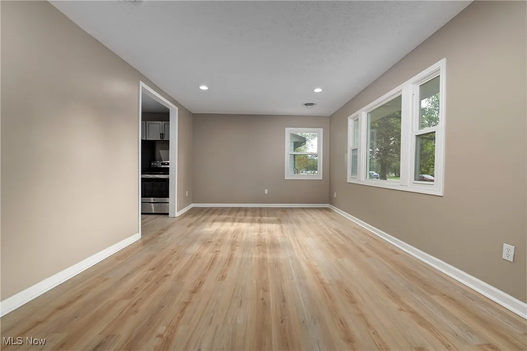 Unfurnished room featuring light wood finished floors, recessed lighting, and a textured ceiling