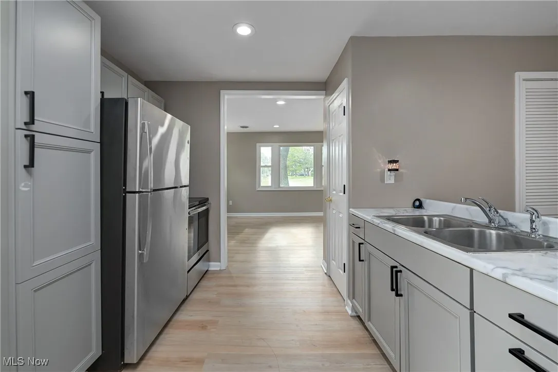Kitchen with light countertops, appliances with stainless steel finishes, light wood-style floors, recessed lighting, and gray cabinetry