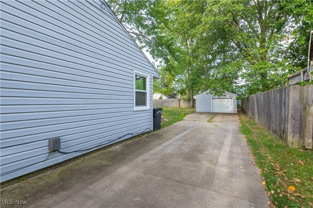 View of driveway with an outdoor structure, a garage, and driveway