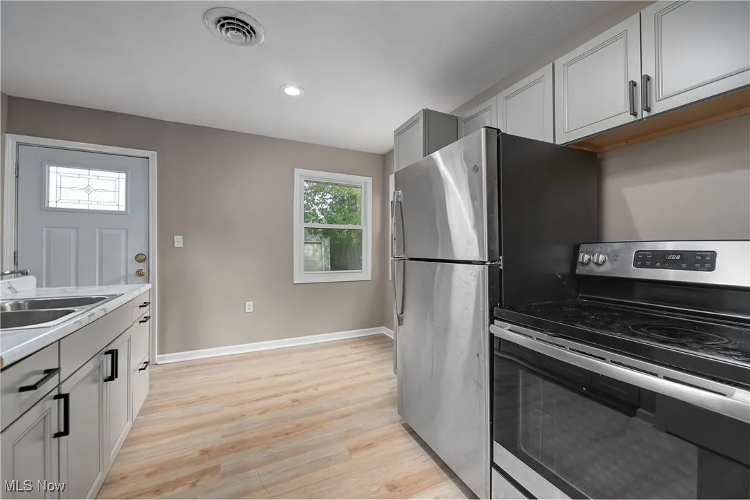Kitchen featuring stainless steel range with electric cooktop, gray cabinetry, light countertops, light wood finished floors, and recessed lighting