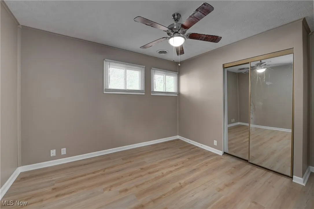 Unfurnished bedroom featuring light wood finished floors, ceiling fan, and a closet