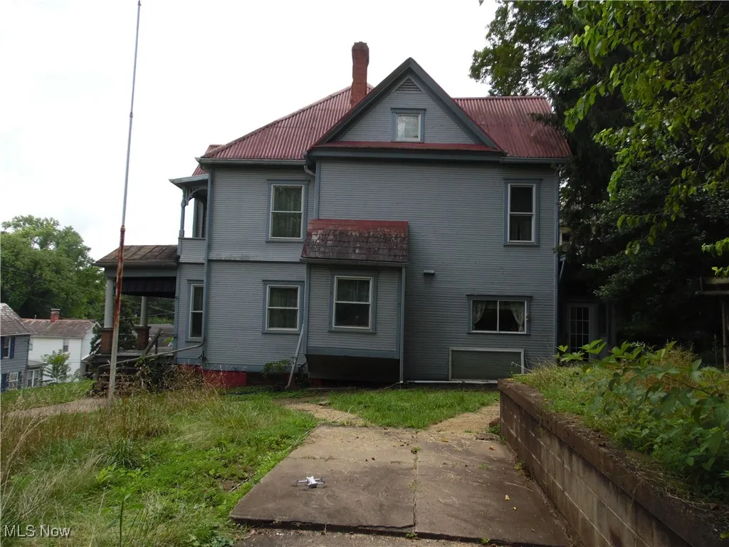 Rear view of property with a chimney and a metal roof