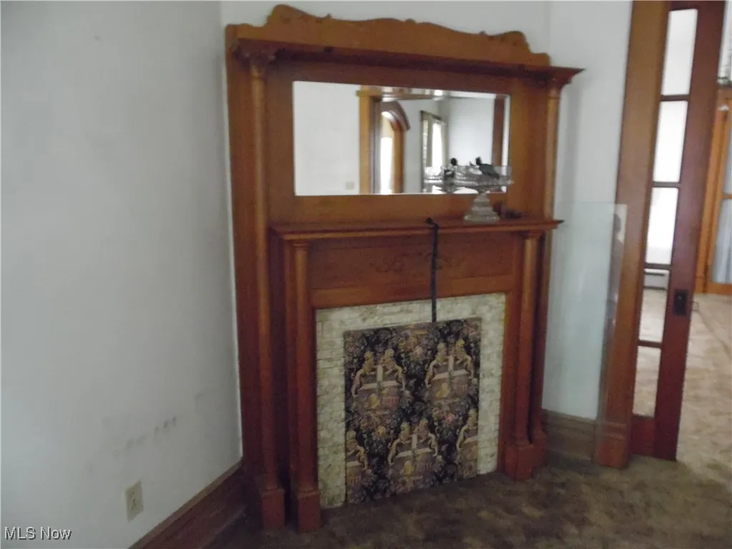 Detailed view of a tiled fireplace and baseboards