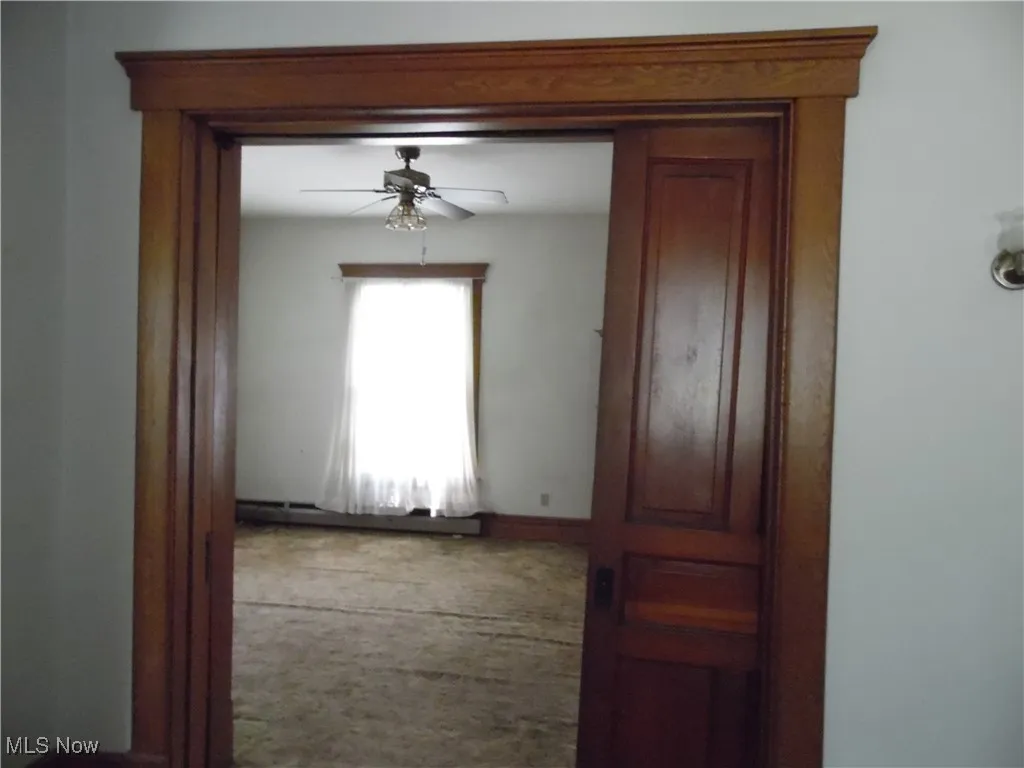Hallway featuring carpet floors and a baseboard radiator