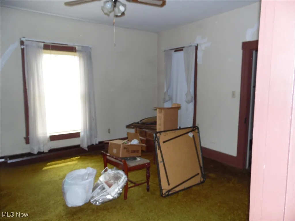 Sitting room featuring a ceiling fan and carpet