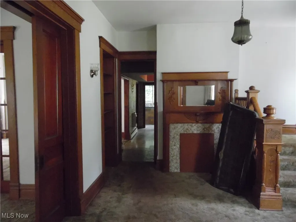 Corridor featuring baseboards and carpet flooring