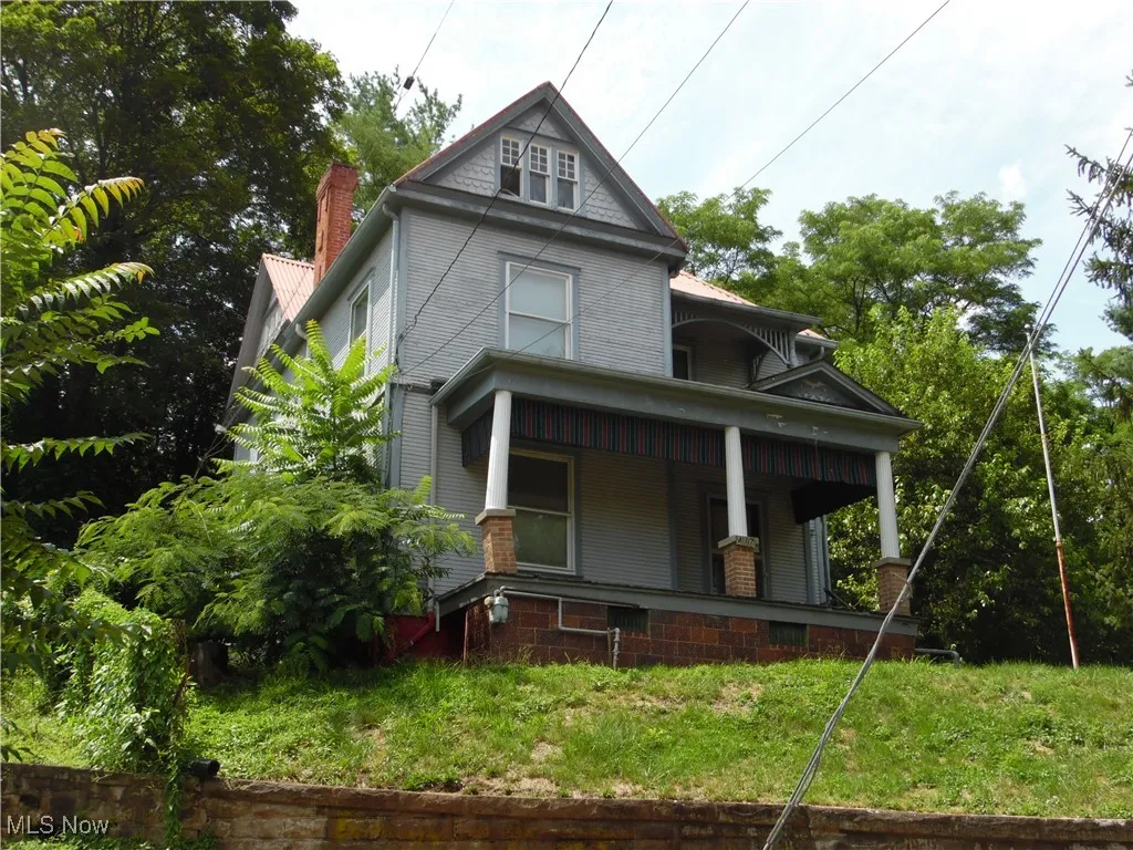 View of front of house with a large porch and a chimney