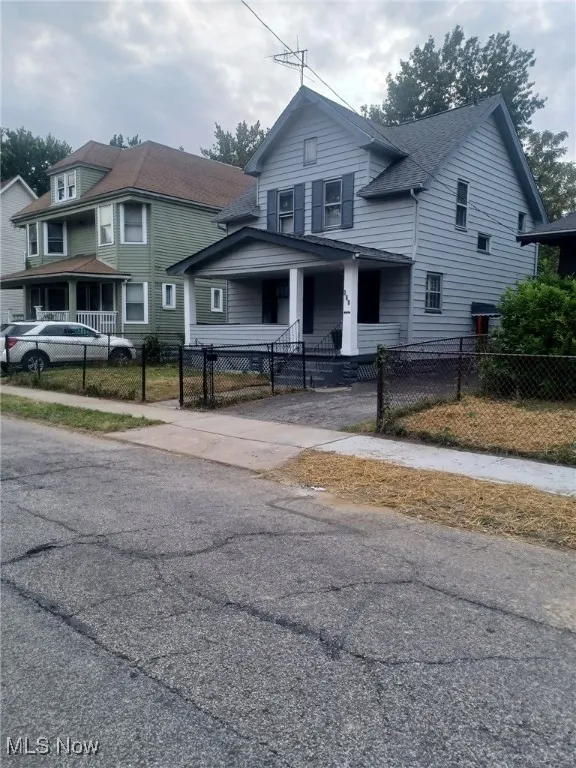 View of front of property with a porch, a fenced front yard, and a gate