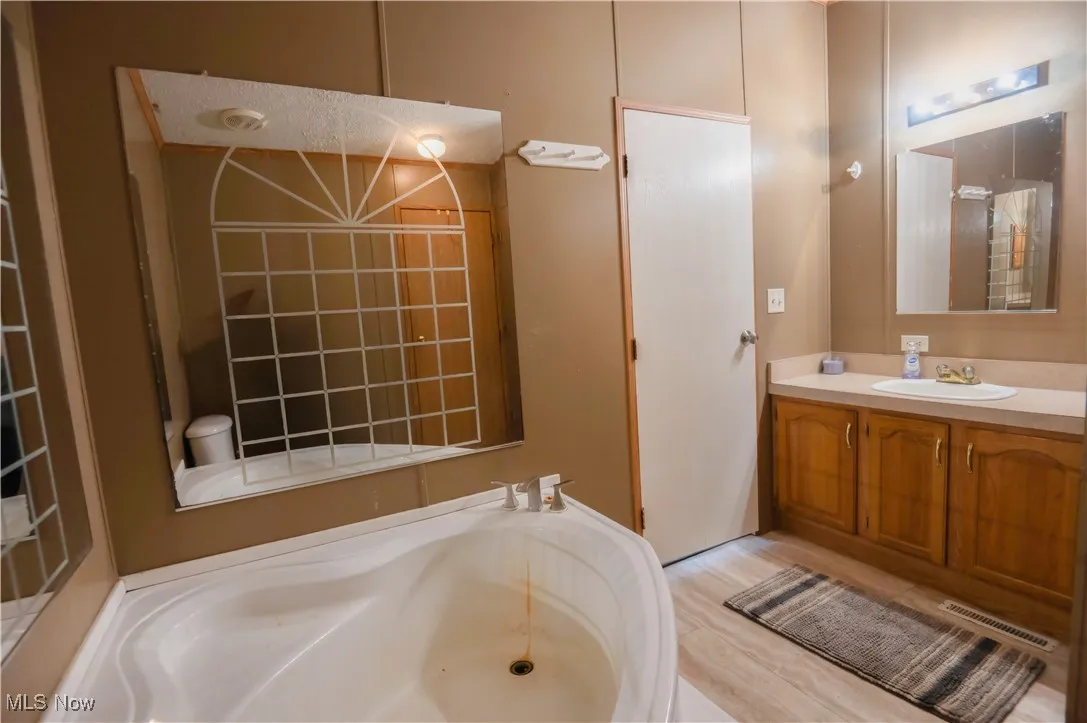 Bathroom with vanity and a bath