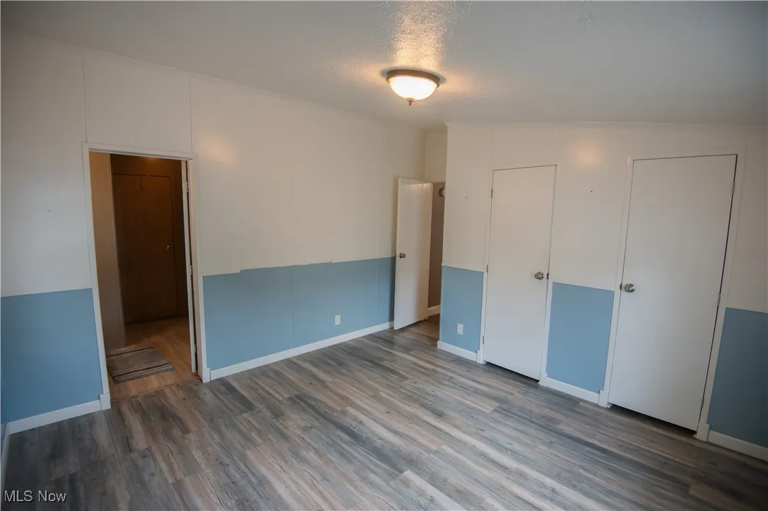 Unfurnished bedroom featuring wood finished floors and a textured ceiling
