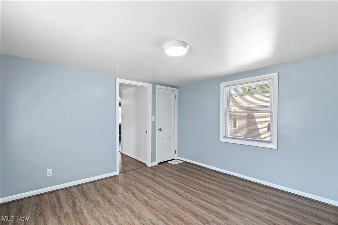 Unfurnished bedroom with wood finished floors and baseboards