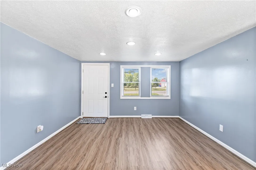 Entrance foyer featuring a textured ceiling, wood finished floors, and recessed lighting