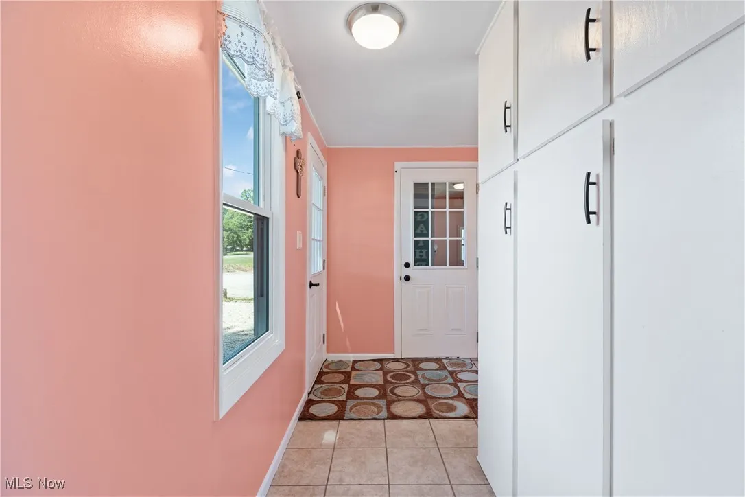 Entryway with tile patterned floors and baseboards