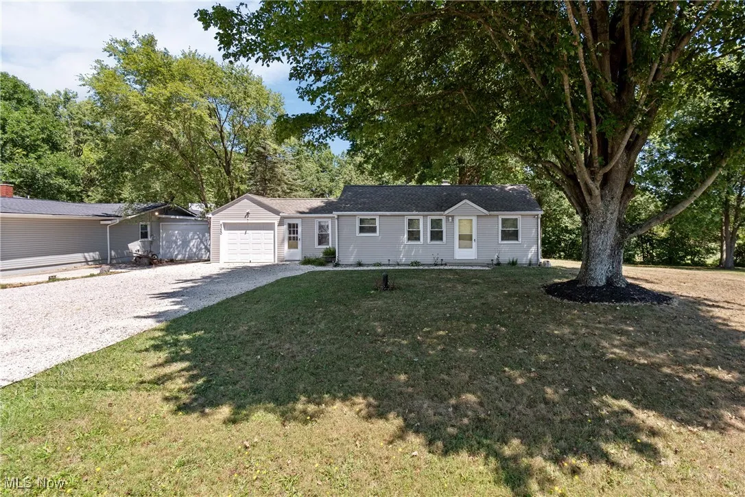 Ranch-style home with a garage, a front yard, and driveway